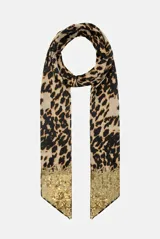 Pashmina larga de poliéster con estampado animal print en tonos beige y negro, decorada en ambos extremos con una franja de lentejuelas doradas.