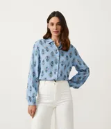 Camisa celeste de viscolino con estampado floral, cuello camisero y mangas largas.