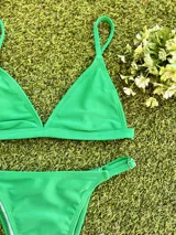 Conjunto de bikini verde esmeralda, con corpiño triangular fijo y bombacha vedetina regulable.