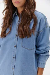 Camisa de jean celeste con botones metálicos envejecidos, manga larga y bolsillo en el pecho.