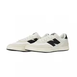Championes urbanos New Balance modelo 440, de diseño bajo con combinación de colores blanco y crema. Presenta el logo 'N' en color negro en los laterales, refuerzos de gamuza en la puntera y talón, y perforaciones decorativas en la parte trasera.