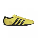 Championes urbanos Adidas modelo Tokyo, color amarillo con las icónicas tres tiras laterales en negro. Presentan un diseño de perfil bajo con suela de goma negra y detalles en gamuza en la zona de los cordones y el talón.