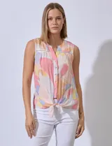 Blusa sin mangas de gasa estampada, con cuello a la base y escote en V. Presenta detalles calados en la delantera, abertura central con botones y terminación anudada.