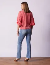 Blusa de gasa con estampado geométrico en tonos negro, gris y celeste. Tiene cuello redondo y mangas 3/4 amplias con abertura y botón.