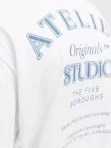 Camiseta blanca de algodón con cuello redondo y corte holgado. Estampado frontal con la leyenda "Atelier Originals Studio The Five Boroughs Established in Nineteen Ninety Designed in Copenhagen Brought to you by Jack & Jones".