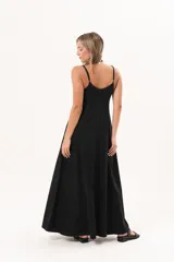 Vestido largo de denim fino y liviano color negro, de breteles finos, escote delicado, silueta entallada arriba y falda amplia con bolsillos laterales.