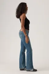 Jeans de mujer de tiro bajo, color azul medio con efecto lavado, corte bootcut y cierre de botón y cremallera.