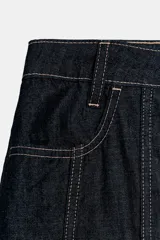 Falda midi de denim azul oscuro con tiro medio, bolsillos delanteros y costuras a contraste. Presenta un diseño con canesú estructurado y falda con frunces, cierre frontal con cremallera y botón metálico.