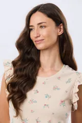 Remera blanca de algodón con delicado estampado floral y volados en las mangas cortas, con diseño de cuello redondo.