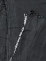 Bufanda rectangular de color negro con estampado abstracto y flecos cortos en los extremos.