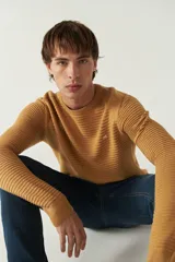 Sweater negro de punto con textura acanalada horizontal, cuello redondo y logo bordado en el pecho.