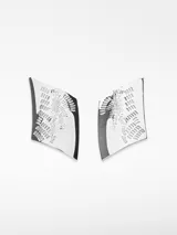 Par de aros colgantes metálicos con forma geométrica irregular y diseño grabado con motivos abstractos. Cierre con broche.