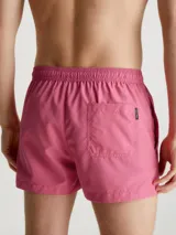 Short de baño corto color rosado con cintura elástica ajustable con cordón blanco y logo CK plateado estampado en la pierna derecha.
