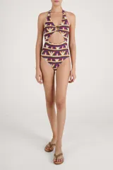 Malla enteriza con estampado geométrico multicolor en tonos beige, fucsia, verde y naranja. Presenta diseño halter con argolla central de madera y abertura frontal en la cintura.