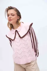 Buzo de punto color rosado con mangas largas a rayas marrones y rosadas. Presenta un doble cuello XL en color rosado con borde marrón y terminación de rulo, además de un cuerpo con detalles de calados y puntos tejidos.
