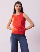 Musculosa tejida color naranja, de hilado fino y cuello redondo.