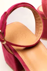 Sandalia de tacón cuadrado medio, confeccionada en terciopelo negro. Presenta un diseño de tiras cruzadas con nudo en la parte delantera y una tira ajustable con hebilla en el tobillo.