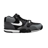 Championes Nike Air Trainer 1 de corte medio, con diseño en combinación de colores negro y gris. Presenta una correa ajustable sobre el empeine con el logo de la marca, el icónico swoosh lateral en color blanco y suela de goma con entresuela blanca.