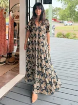 Vestido largo de corte amplio con estampado floral en tonos turquesa, blanco y rosa. Posee escote en V, mangas cortas y espalda con lazo.