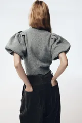 Jersey de punto de cuello redondo con mangas cortas abullonadas y acabado acanalado en el ruedo.