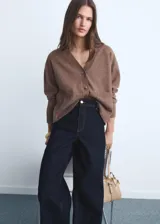 Jeans tiro alto de corte culotte y pierna ancha, en denim azul oscuro con bajo deshilachado, trabillas para cinto y bolsillos traseros.