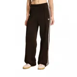 Pantalon deportivo adidas modelo Firebird Loose, color marrón oscuro con las icónicas tres tiras laterales en color crema. Presenta corte holgado, cintura elástica y logo del trébol bordado en la pierna.