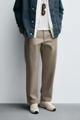 Pantalón de corte recto confeccionado en tejido de algodón con estructura twill, con bolsillos frontales y bolsillos traseros de vivo con botón.