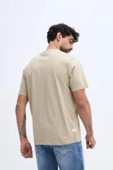 Remera de algodón color beige con fit regular, cuello redondo, mangas cortas y estampa circular en el pecho.