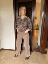 Camisa de color marrón chocolate con estampado floral en tono beige, de corte relajado, manga larga con puños elásticos y cierre frontal con botones.