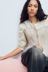Top estilo corset de escote corazón y hombros descubiertos, con varillas interiores para estructura. Presenta cierre frontal con ganchos metálicos y ajuste posterior mediante cordones cruzados.