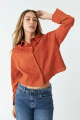 Camisa de manga larga color ladrillo con rayas verticales en relieve.