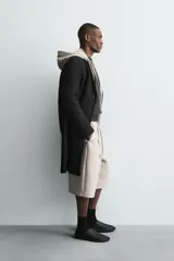 Bermuda de corte oversize confeccionada en tejido técnico compacto con elasticidad. Presenta cintura elástica ajustable con cordón, pinzas en el delantero y la espalda, y bolsillos laterales.