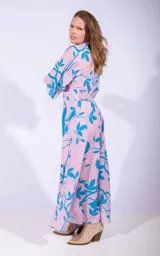 Vestido midi color lila con estampado de hojas turquesas, corte cruzado, mangas 3/4 y lazo en la cintura.