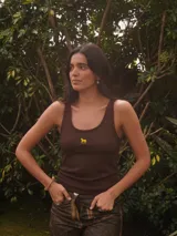 Top de punto acanalado marrón, con diseño ajustado y escote redondo. Cuenta con un pequeño bordado en hilo amarillo de un caballo en el centro del pecho.