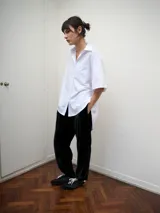 Pantalón de corte amplio y relajado confeccionado en terciopelo negro. Presenta cintura elástica, bolsillos laterales y diseño de pierna recta.