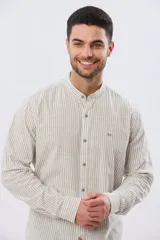 Camisa de manga larga con diseño de rayas verticales, confeccionada en mezcla de lino y algodón. Presenta cuello mao, cierre frontal con botones y bordado sutil en el pecho.