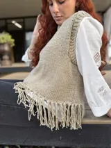 Chaleco tejido a mano color beige con cuello alto y flecos en el ruedo. Hecho por encargo en lana.