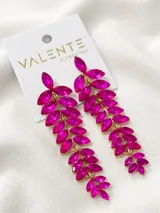 Aros colgantes largos con piedras fucsia en forma de hoja y engarce dorado.