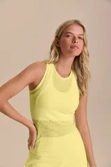 Musculosa deportiva de calce ajustado, confeccionada en tejido técnico con textura microperforada para mayor transpirabilidad. Presenta cuello redondo y diseño anatómico que favorece la libertad de movimiento.