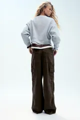 Pantalón cargo de tiro medio confeccionado en denim negro con efecto lavado. Presenta bolsillos laterales con solapa, bolsillos delanteros y traseros, corte recto y cinturón del mismo tejido incluido con hebilla metálica.