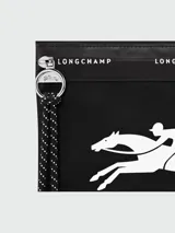 Pouch de mano Longchamp modelo Le Pliage Energy, color negro con estampado del logo ecuestre en blanco. Cuenta con cierre superior, tirador de cierre con cordón decorativo y detalle de cinta con el nombre de la marca.