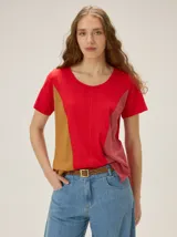 Remera de manga corta con diseño de bloques de color en tonos rojo, tostado y rosado, cuello redondo y costuras verticales decorativas.