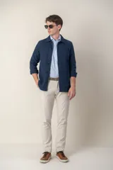 Sobre camisa color verde militar de lino con cuello clásico, manga larga con puños abotonados, cierre frontal con botones a tono y bolsillos de parche en el pecho.