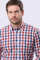 Camisa de corte sport con estampado de cuadros en tonos rojo, azul y blanco. Presenta cuello abotonado, cierre frontal con botones y bolsillo en el pecho con detalle bordado.