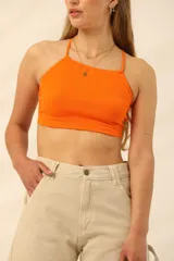 Top corto naranja de lycra de algodón, con espalda descubierta y breteles finos.