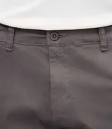 Pantalón slim de sarga lavada para hombre, de corte ajustado y color beige, con bolsillos laterales y traseros, trabillas para cinturón y cierre frontal con botón y cremallera.