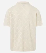 Camisa de manga corta color crema, confeccionada en tejido de punto con diseño de rombos calados y pequeños bordados florales en el centro de cada rombo. Posee cuello cubano y cierre frontal de botones.