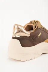 Zapatilla urbana de cuero color marrón con detalles en beige y dorado.