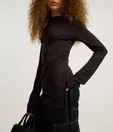 Blusa roja ajustada de manga larga, confeccionada en tejido rib, con cuello redondo y diseño largo con fruncidos laterales y aberturas en los costados.