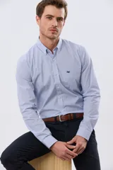 Camisa de manga larga con estampado de cuadros pequeños, cuello abotonado, cierre frontal con botones y un bolsillo en el pecho con detalle bordado.